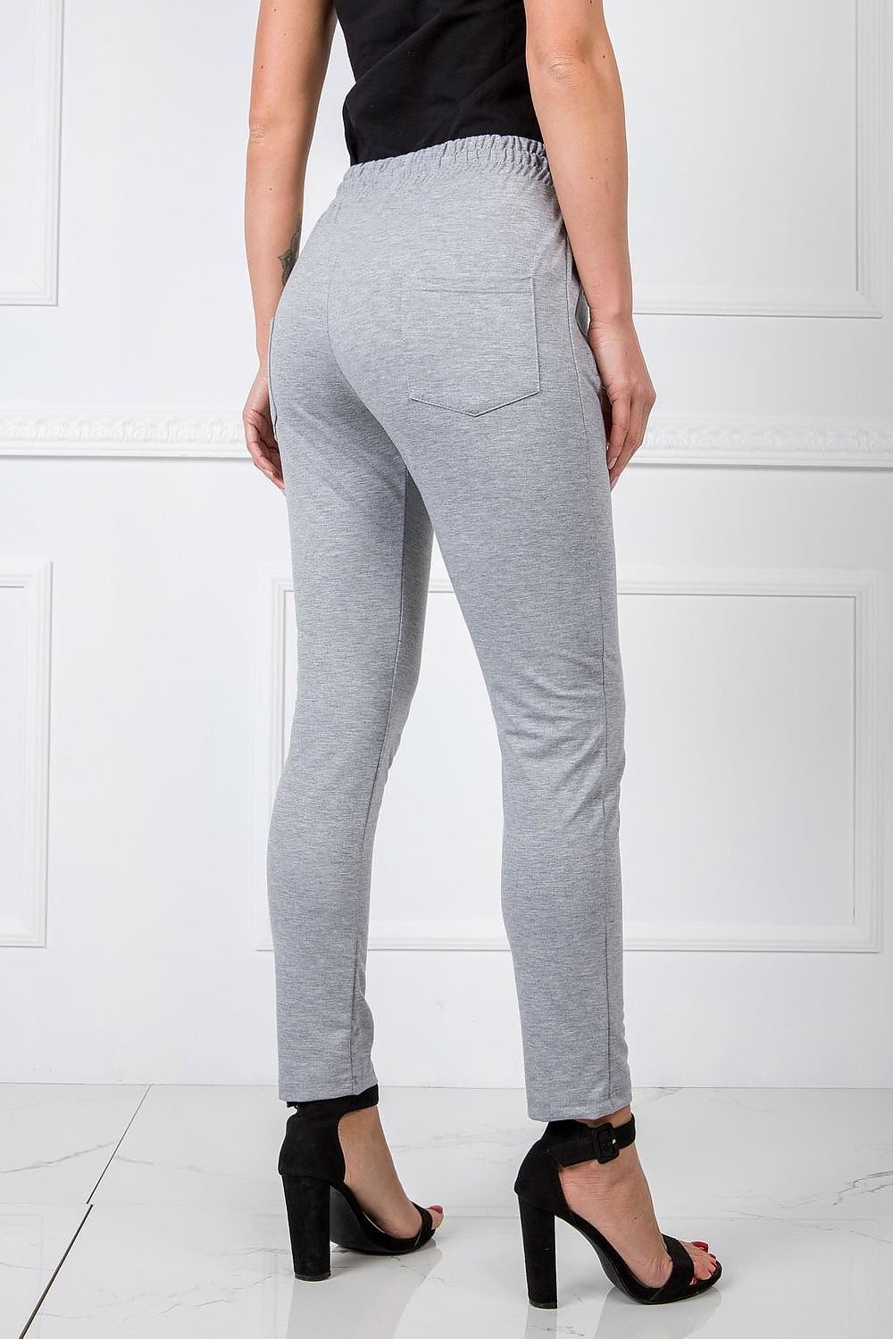 Back view of BFG Women’s High-Waisted Slim Leg Tracksuit Trousers, demonstrating the chic fit and stylish design, complemented by the model's black top and high heels, perfect for luxury casual wear.