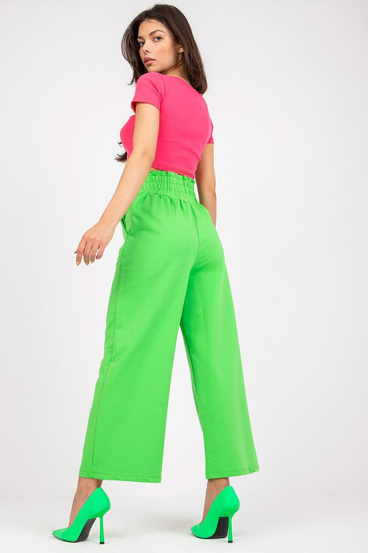 Luxury High-Waist Tracksuit Trousers with Wide Legs and Slip-On Pockets in Cotton-Spandex Blend, model displaying back view of the bright green trousers paired with a pink crop top and chic green heels.