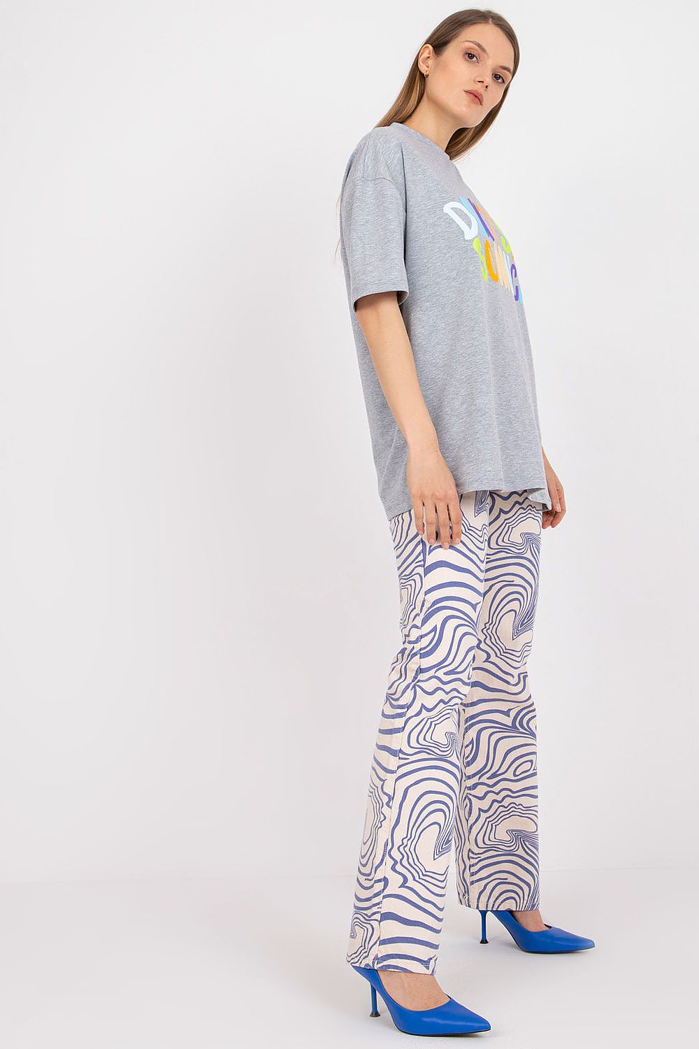 Elegant Stylish Loose-Fit Ladies' T-Shirt with Decorative Front Wording, showcased alongside stylish patterned trousers for a sophisticated attire.