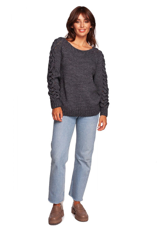 Luxury fitted jumper with shoulder revealing neckline and thick plaid sleeve weave, modelled in dark grey, styled with light blue jeans.