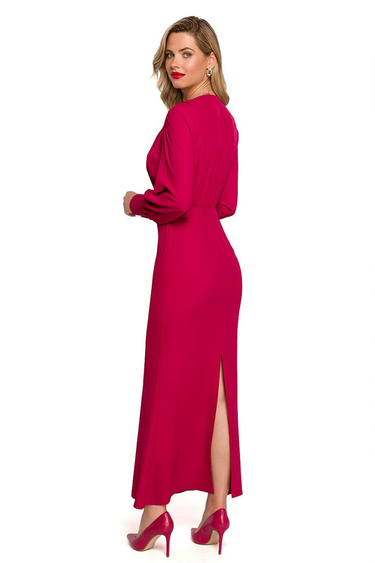 Maxi Cocktail Dress With Deep Neckline, Voluminous Sleeves And Elegant Slit By Makover, elegantly displayed from the back, highlighting the alluring slit and the flowing silhouette of the dress in a vibrant fuchsia hue.