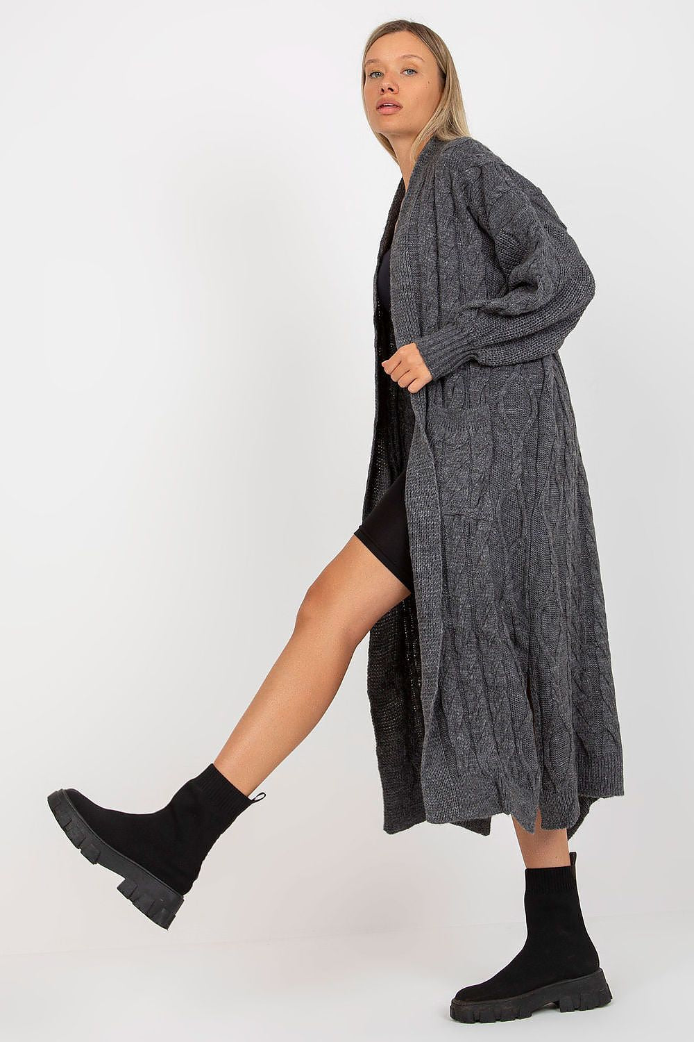 Luxury Long Sleeve No-Fastening Cardigan With Large Pockets by Rue Paris, displayed with a model in a dynamic pose, dressed in a black ensemble and trendy black footwear, highlighting the cardigan's exquisite design.