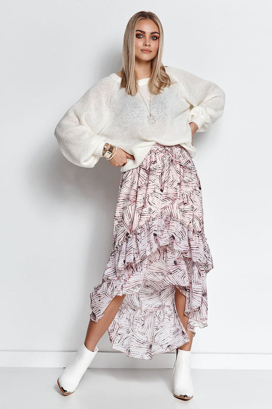 Fashionable lady showcasing a luxurious Makadamia women’s sweater in cream, combined with a flowing ruffled skirt, perfect for both casual and business attire.