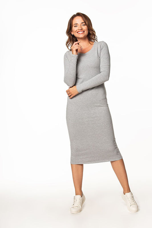 Stylish long cotton knit dress from Tessita showcased on a cheerful model, highlighting its boat neckline and slim fit.