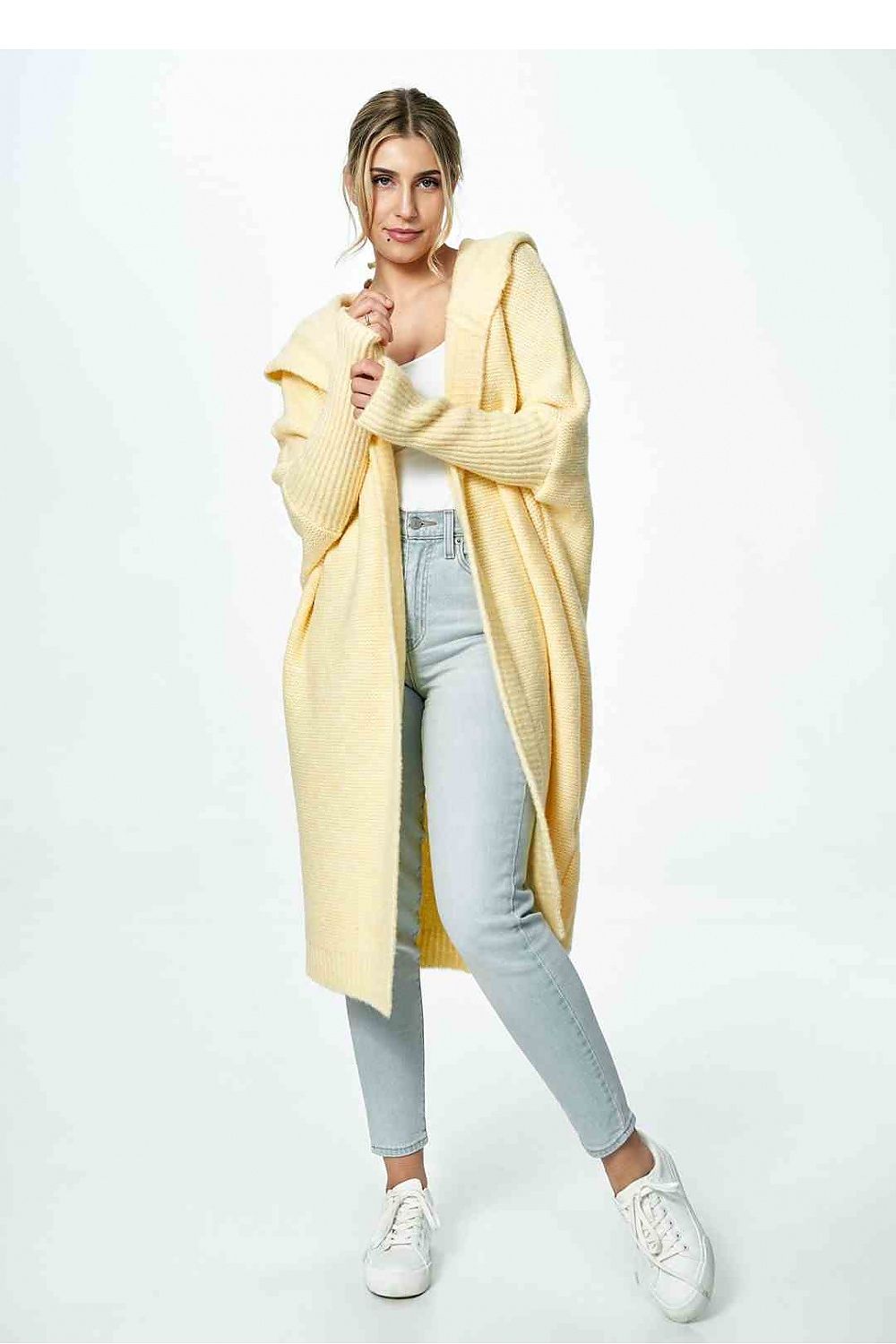 Front view of an elegant yellow Figl cardigan worn over a white top and blue jeans, highlighting its sophisticated style.