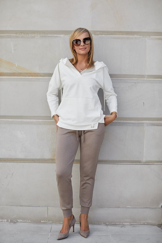 Chic women's outfit featuring luxurious viscose stretch trousers paired with a sophisticated white hoodie, accentuated by elegant high-heeled shoes, exemplifying a blend of sporty and elegant fashion.