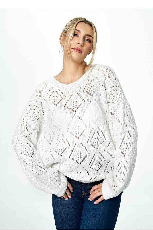 Elegant feminine white openwork sweater with a half round neckline and long sleeves, styled with dark denim jeans, exuding contemporary chic.