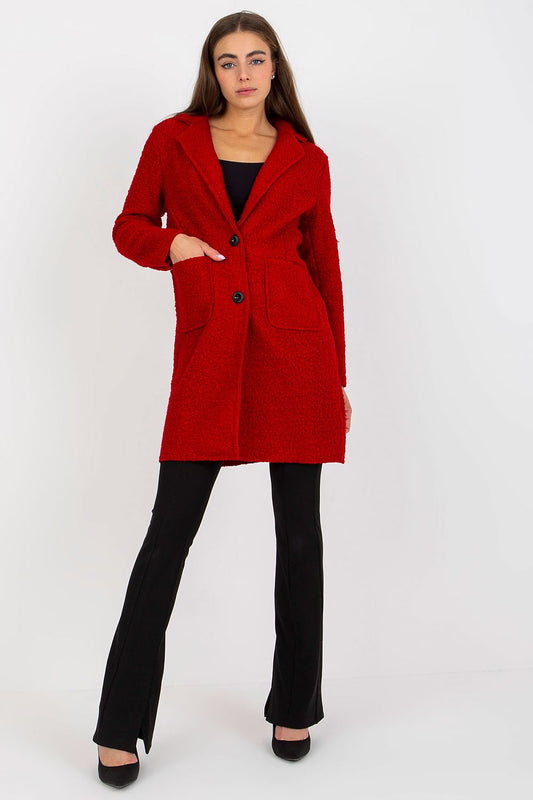 Chic women's red buttoned coat from Och Bella, showcasing a sleek silhouette with patch slip pockets, paired with black flared pants, exuding sophistication in a clean setting.