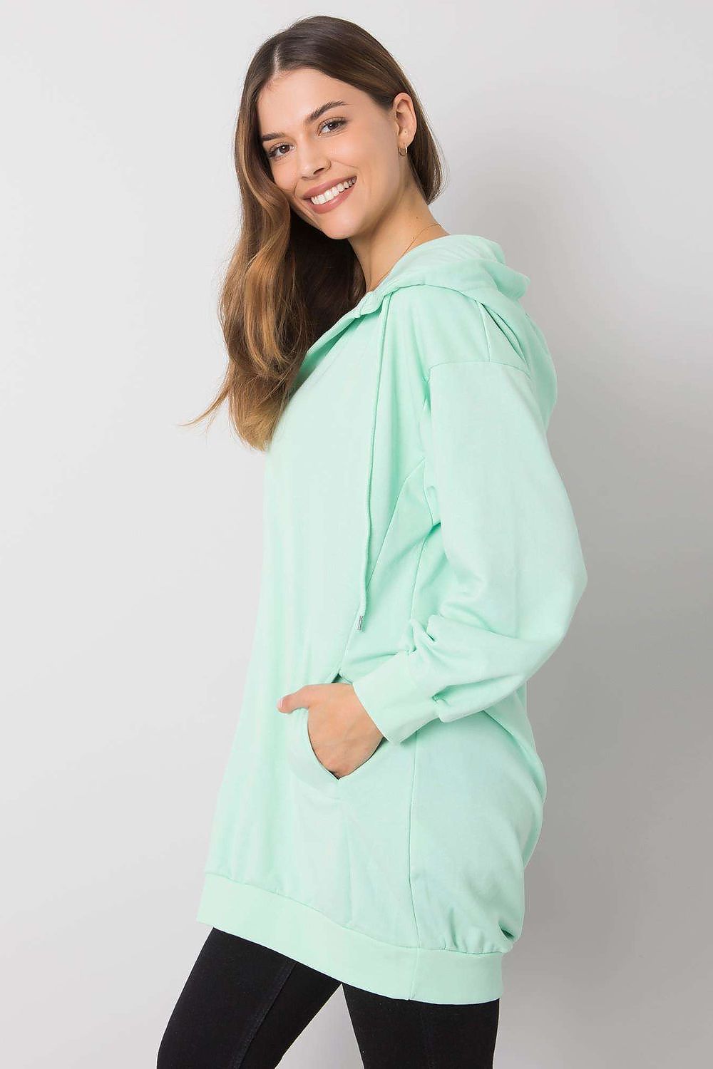 Chic side view of a mint green women's hooded sweatshirt showcasing its relaxed fit, kangaroo pocket, and luxurious fabric, perfect for daily elegance.