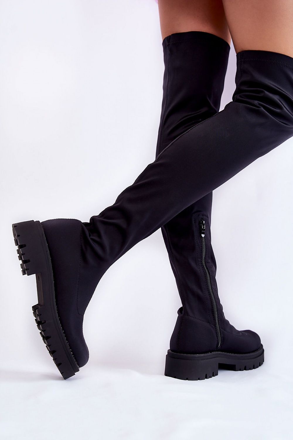 Chic black thigh-high musketeer boots showcasing a contemporary silhouette with durable flat soles and textured platform, ideal for adding a touch of sophistication to any outfit.