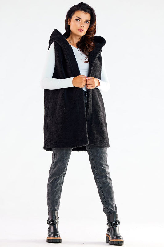Fashionable model showcasing a trendy black hooded gilet vest, designed for comfort and versatility, complemented with sophisticated denim for a casual yet elegant look.