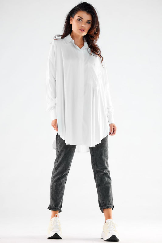 Stylish women's oversized white shirt with long sleeves, paired with grey slouchy trousers and sneakers, epitomising contemporary luxury and effortless elegance.