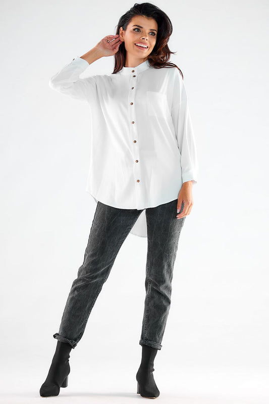 Stylish model showcasing an elegant long sleeve buttoned shirt with an extended back from Awama, crafted in Poland, paired with chic jeans and ankle boots.