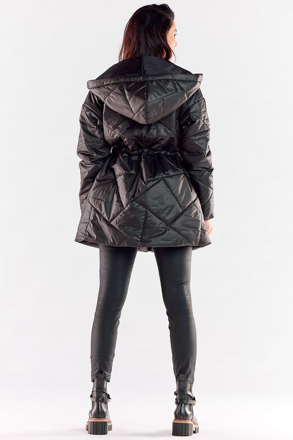 Fashion-forward woman displaying the back view of a black quilted hooded jacket, highlighting the tailored fit and luxury design.