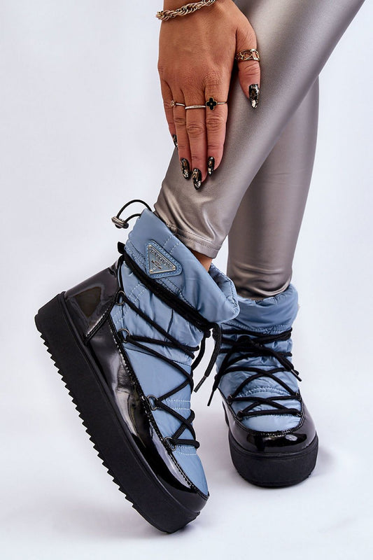 Close-up view of elegant women's snow boots in blue hues, made with eco leather and designed for warmth, styled with fashionable accessories.