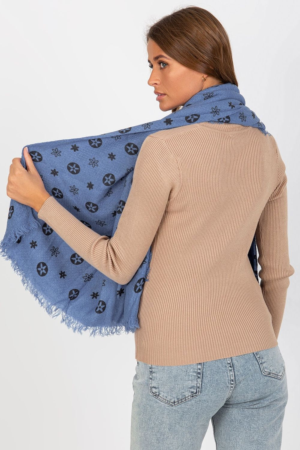 A sophisticated view of a woman from behind, elegantly styling a luxury 100% acrylic neckerchief in a rich blue colour, featuring a fashionable pattern, paired beautifully with denim.