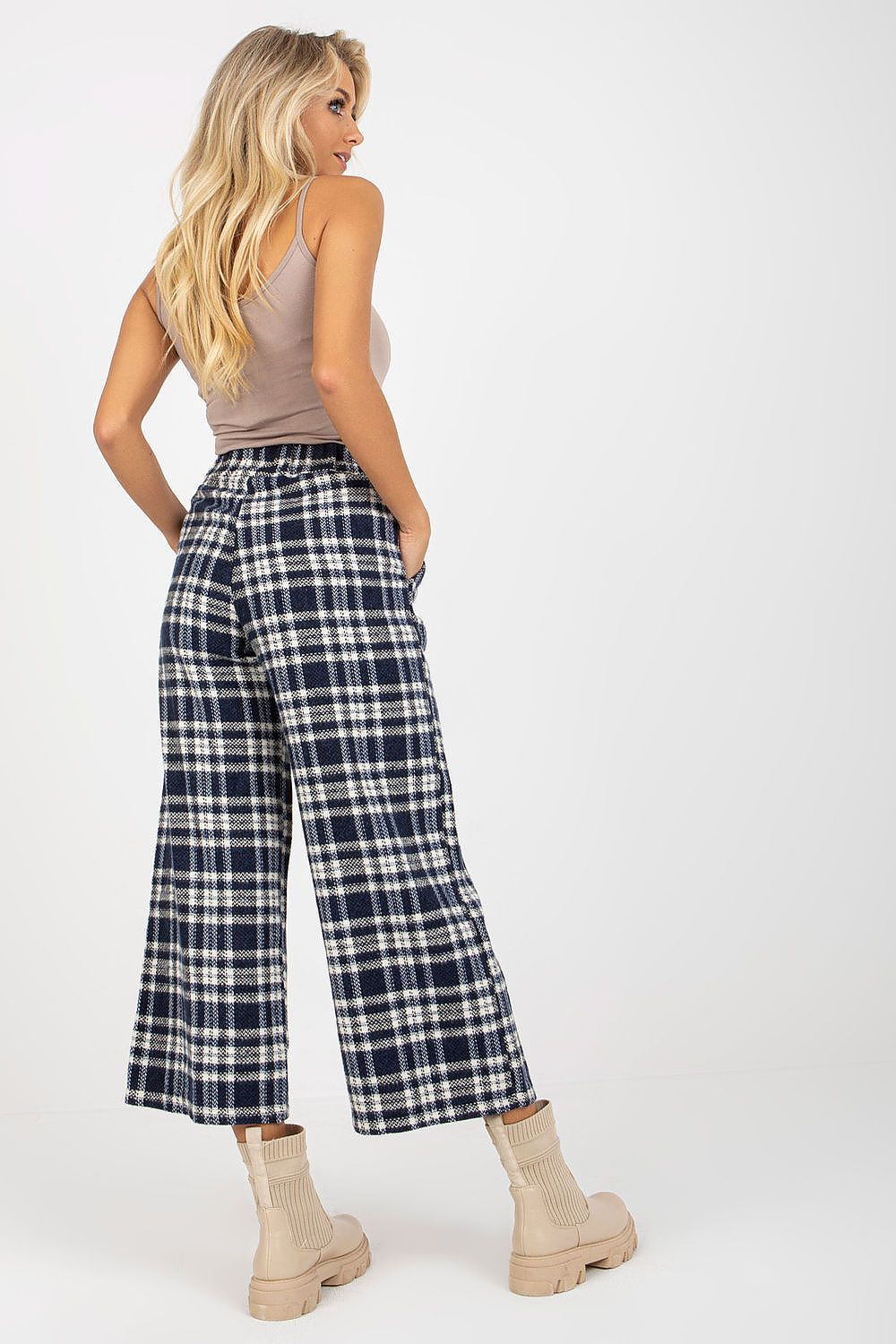 Gracious model captured from the back, highlighting the stylish checkered trousers and chic beige top, exuding effortless elegance.