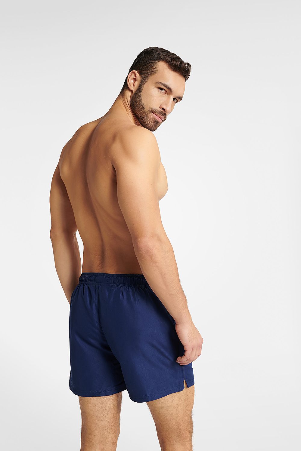 Elegant rear view of Henderson GUARD navy blue swimming trunks on a male model, highlighting the classic cut and quality craftsmanship for a luxurious swimwear experience.