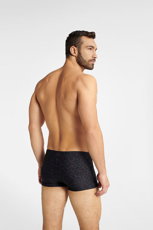 Henderson GLOBE Men's black swim trunks featuring a sleek boxer style with a modern grey-red pattern, showcased on a model from a rear angle, ideal for luxurious beach days and aquatic adventures.