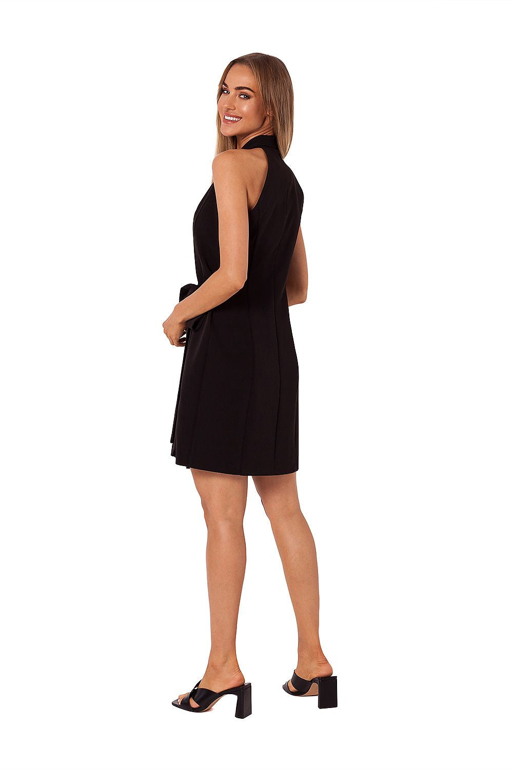 Graceful model showcasing the elegant Jacquard overlap daydress with side tie by Moe, featuring a sophisticated cut and stylish design. The dress is complemented by chic black heels, exuding luxury and refinement.