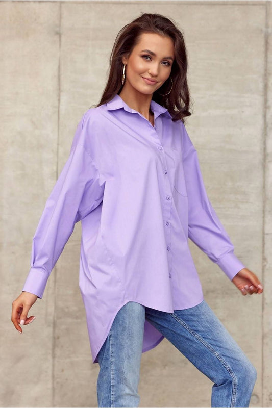 Stylish model poses in Roco Fashion Women's oversized long sleeve shirt in soft lavender, emphasizing its chic asymmetrical design and comfortable fit, set in a contemporary architectural setting.