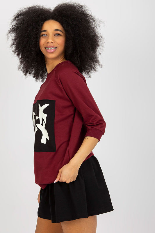 Chic side view of a model wearing the elegant 2-piece sweatshirt set by Fancy, highlighting the stylish maroon sweatshirt and black skirt combination, ideal for trendy outfits.