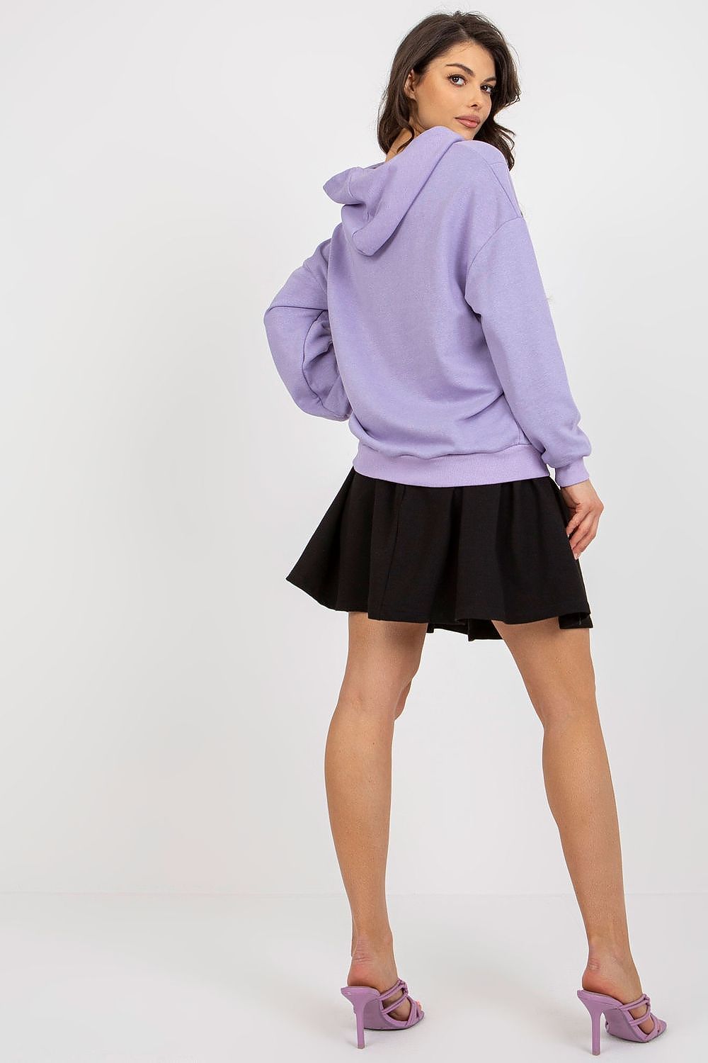 Elegant model wearing a luxury cotton spandex sweatshirt set by Fancy, featuring a lilac hoodie and a flared black skirt, showcasing a chic and contemporary style.