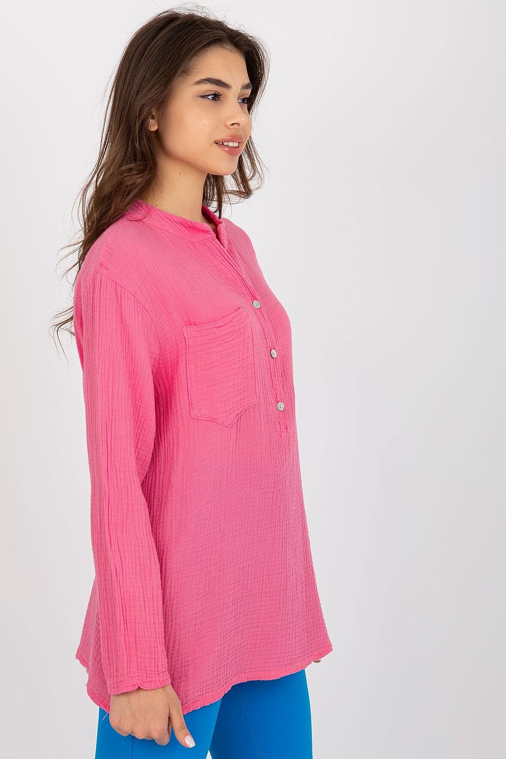 Side view of the Och Bella luxurious cotton muslin blouse in bright pink featuring long sleeves and a v-neck, exemplifying a chic and relaxed silhouette.