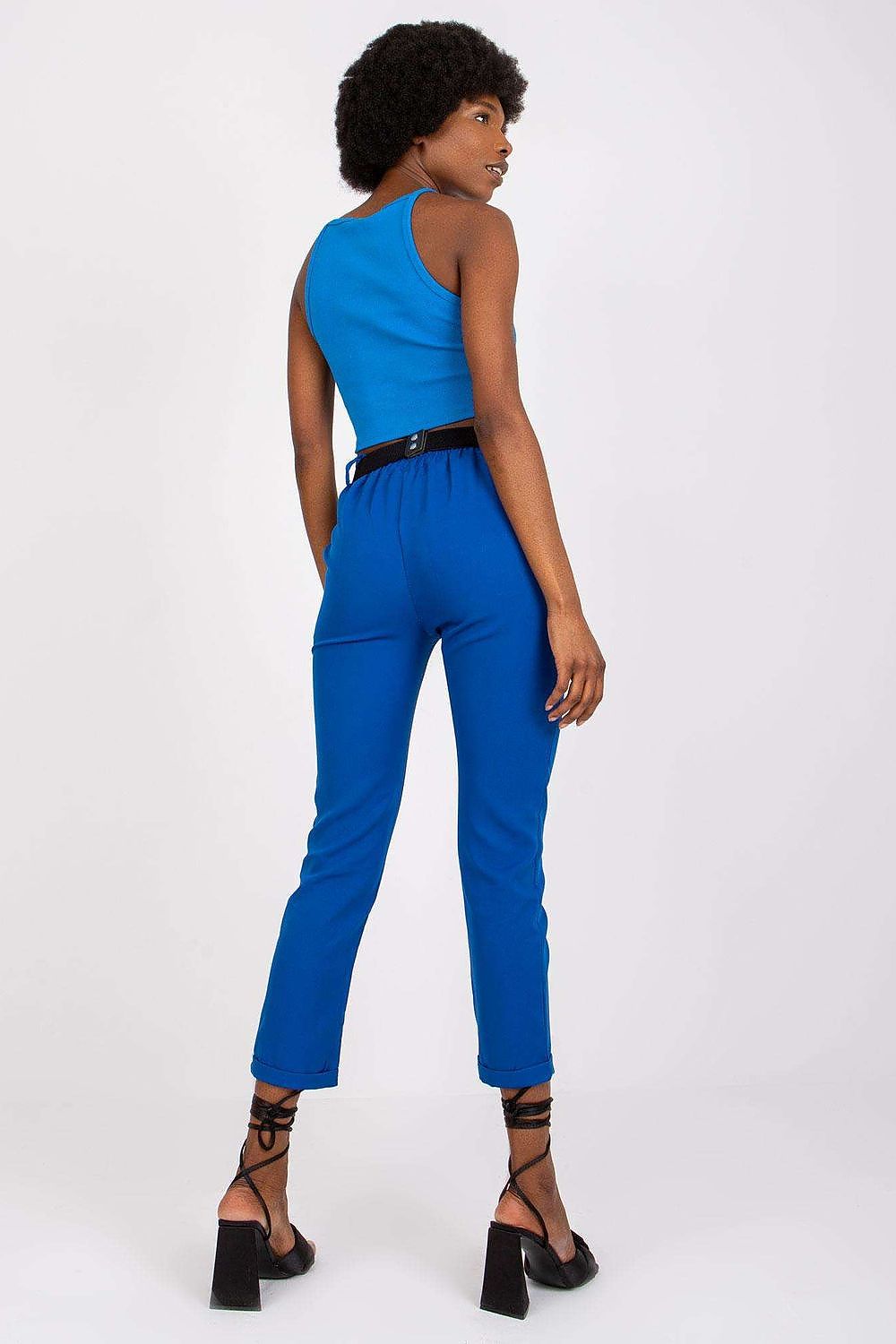 Back view of a model in Luxury Women’s High Rise Trousers by Italy Moda in striking blue, styled with a fitted tank top and a decorative belt.