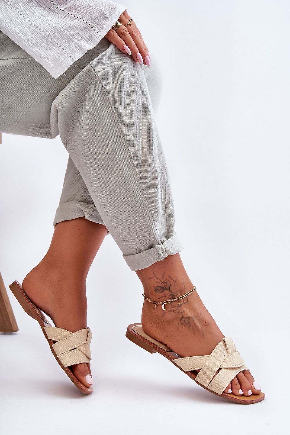 Luxurious women's flat-heeled flip-flops by Step in Style featuring elegant interlaced straps and a non-slip rubber sole, perfect for summer comfort.