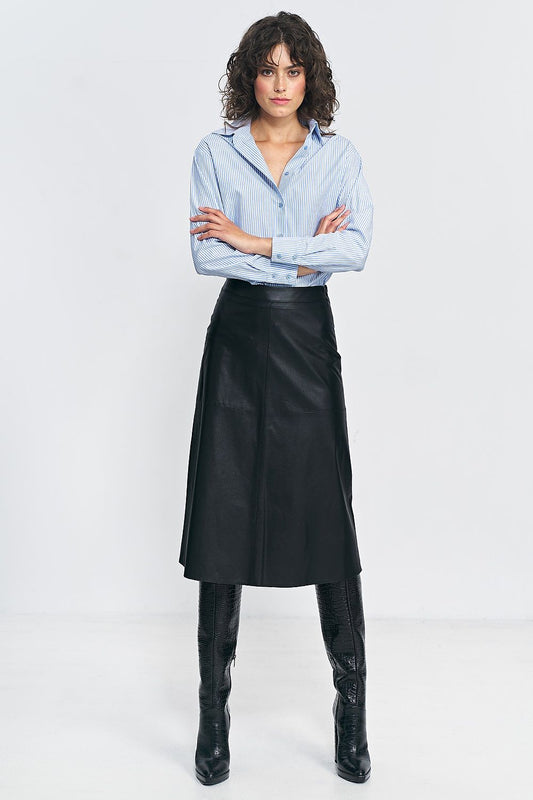 Luxurious Nife imitation leather skirt styled for autumn with chic boots, enhancing the silhouette.