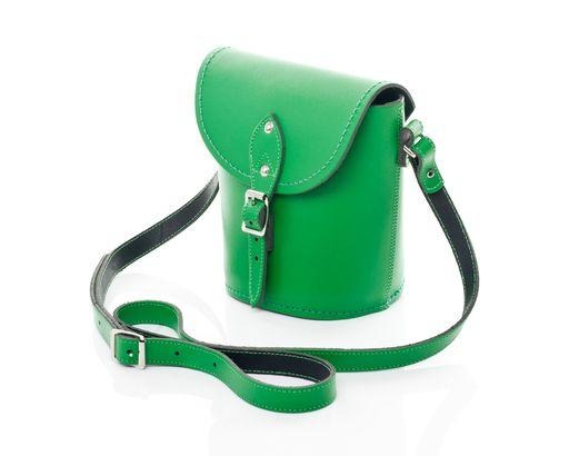 Handmade green leather barrel bag showcasing quality craftsmanship, complete with adjustable strap and elegant silver nickel buckle.