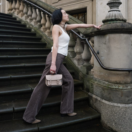 Versatile Iced Coffee Leather Micro Satchel featuring an adjustable shoulder strap, elegantly presented in a casual setting to showcase its stylish design and practical features for every occasion.