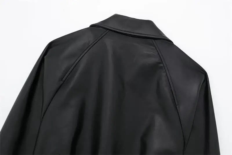 Stylish black leatherette cropped trench coat, featuring elegant details like long sleeve tabs and a belted hem for a polished appearance.