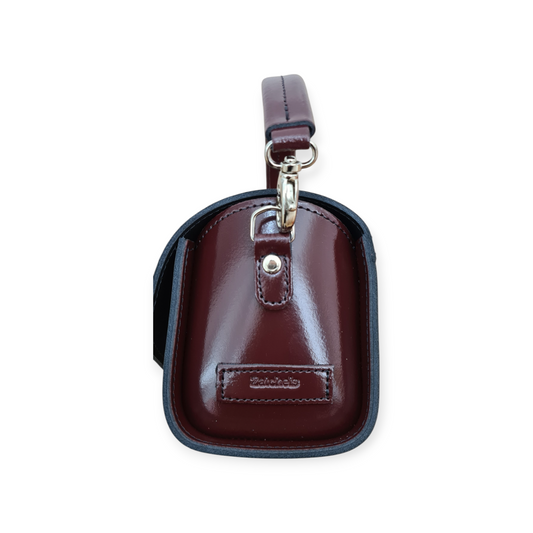 Close-up of the intricate details of the Bauble High-Shine Leather Handbag in Marsala Red, highlighting its premium leather texture.