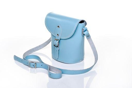 Handmade pastel baby blue leather barrel bag with adjustable strap, showcasing elegant design and high-quality craftsmanship from Zatchels.