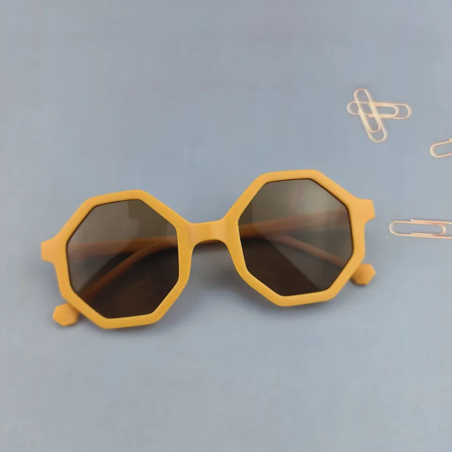 High-quality crafted full-frame sunglasses for children, boasting tinted lenses and a unique polygon style, designed for chic summer days.