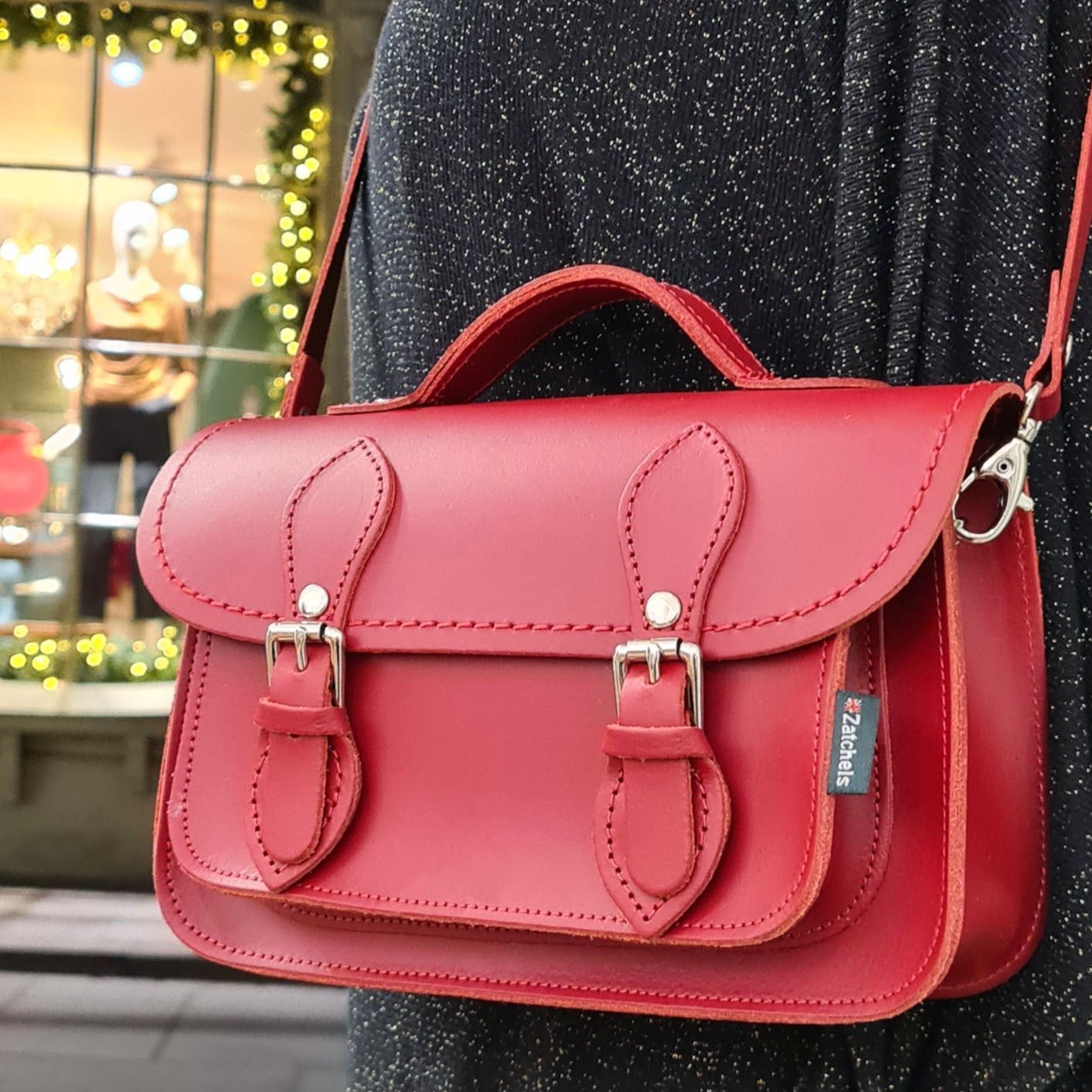 Handmade Red Leather Micro Satchel alongside essentials, illustrating spacious interior and practicality for everyday elegance.