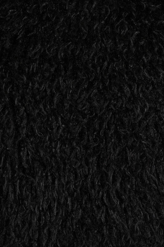Close-up of the Banned Zafira Cropped Jacket's plush faux fur fabric, highlighting its rich black colour and intricate shaggy pattern, ideal for adding a rebellious edge to any outfit.