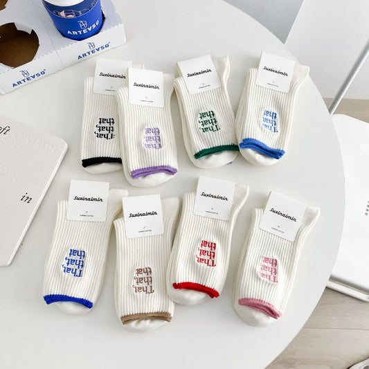 Elegant White Embroidered Socks for Women with Unique Japanese-Style Font Design displayed on a table with various colours and tag information.