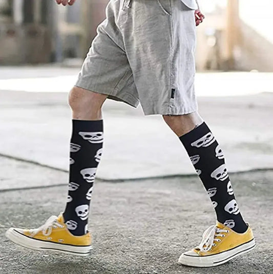 A model wearing women's knee length compression travel socks with a skull pattern, styled with casual shorts and yellow sneakers, showcasing comfort and fashion for travel.