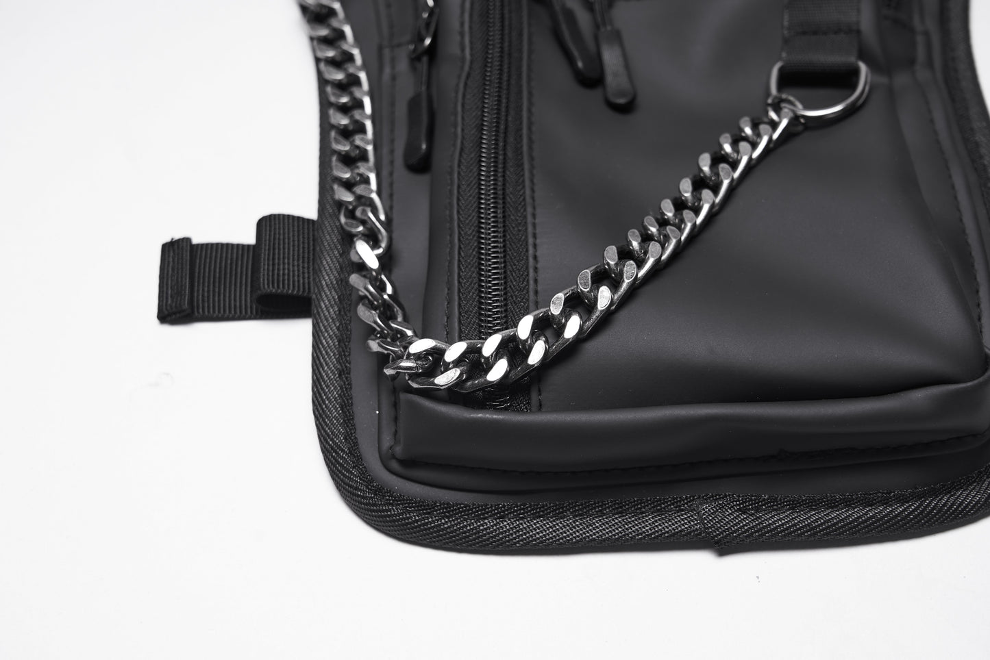 Side profile of the Punk Rave Cyberpunk Waist-Leg Bag, highlighting the rebellious industrial aesthetic with metal rivets and a stylish chain.