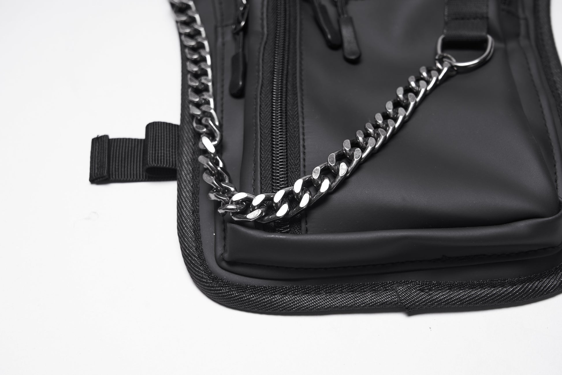 Side profile of the Punk Rave Cyberpunk Waist-Leg Bag, highlighting the rebellious industrial aesthetic with metal rivets and a stylish chain.
