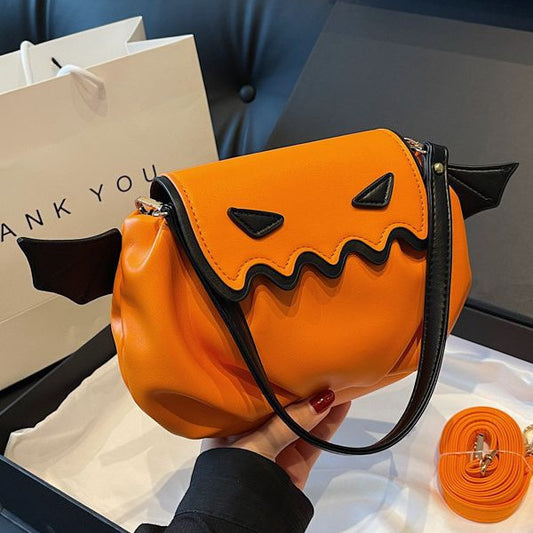 Funny Crossbody Bag - Halloween Pumpkin Cartoon Design with small wings, elegantly displayed in hand against a stylish backdrop.