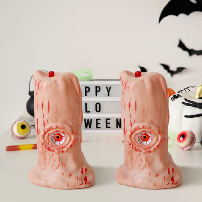Halloween Blood Eye Lamp LED Electronic Light-emitting Candle Light positioned near festive Halloween decorations, featuring two intricately designed candles that evoke a sense of refined spookiness.