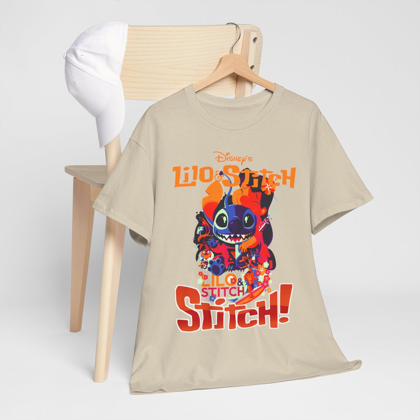 Stylish Lilo & Stitch t-shirt displayed on a wooden chair alongside a white cap, exuding a laid-back yet refined aesthetic, great for fashionable Disney lovers.
