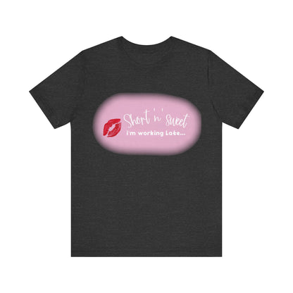 Sabrina Carpenter Inspired Unisex Short Sleeve Tee with Vibrant Lipstick Print in dark heather, featuring the message 'Short n sweet, I'm working Late...' and a stylish lipstick motif.