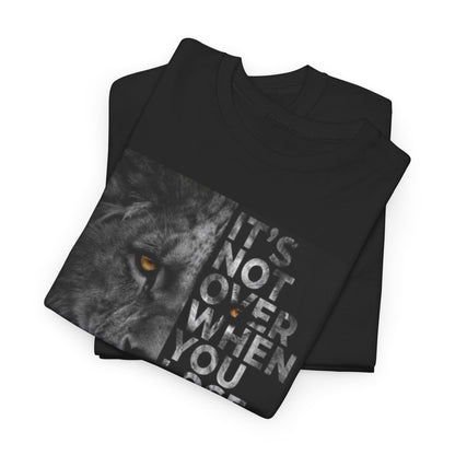 Embrace determination with the 'It's Not Over' graphic unisex t-shirt by Dazzling Dreams, adorned with a striking lion design and a motivational quote for style and strength.