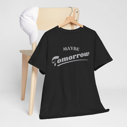 Stylish black Maybe Tomorrow T-shirt elegantly draped over a chair, paired with a classic white cap, showcasing the chic light grey graphic design.