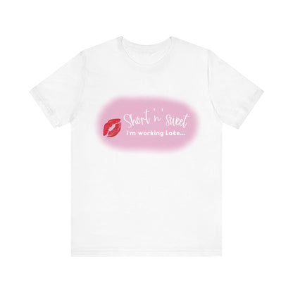Sabrina Carpenter Inspired Unisex Short Sleeve Tee with Vibrant Lipstick Print in classic white, featuring the chic saying 'Short 'n' sweet, I'm working Late...' designed for a sophisticated wardrobe.